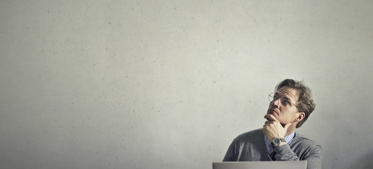 a man sitting at the desk and looking at the celling and thinking