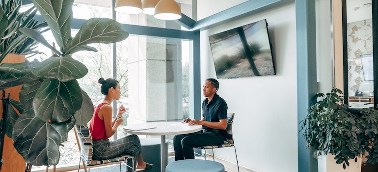 A man and a woman sitting in the office.