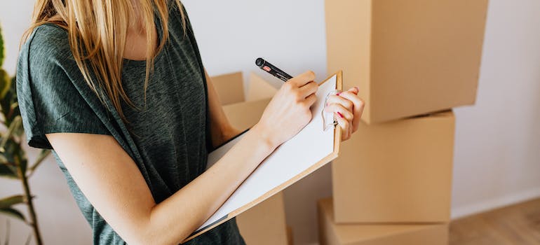 Woman writing efficient packing tips when moving from Canada to the US on the paper