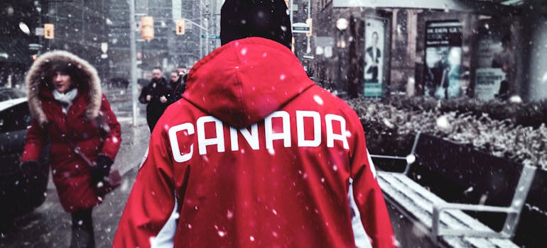 A person in a red jacket that says "Canada".