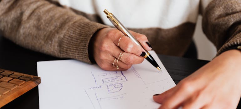 A person drawing ideas to upcycle old furniture after moving.