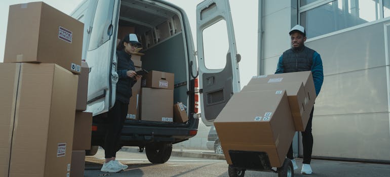 Movers unloading boxes from a van.