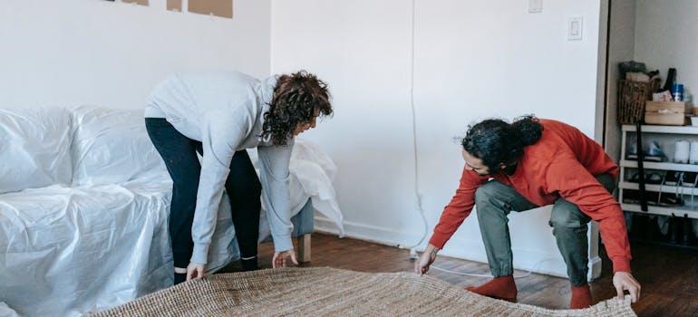 A couple packing and moving rugs in Ontario.