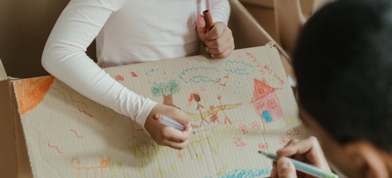 A family drawing on moving boxes.