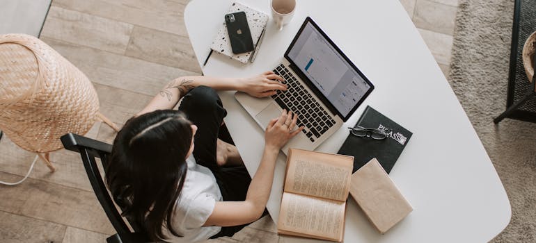 A woman working in her home office and library after moving from Canada to the US.