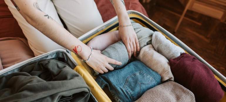 A person packing clothes for moving your belongings to the US from Canada.