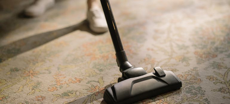 A person vacuuming after decluttering before an international move out of Ontario.