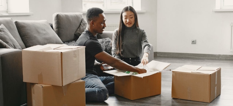A couple packing boxes after renting storage in Sudbury ON.