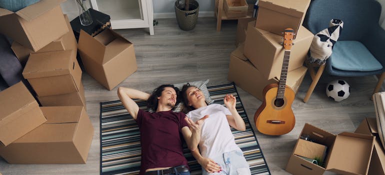 A couple surrounded by moving boxes.
