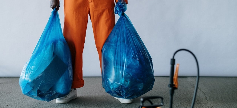 person holding trash bags