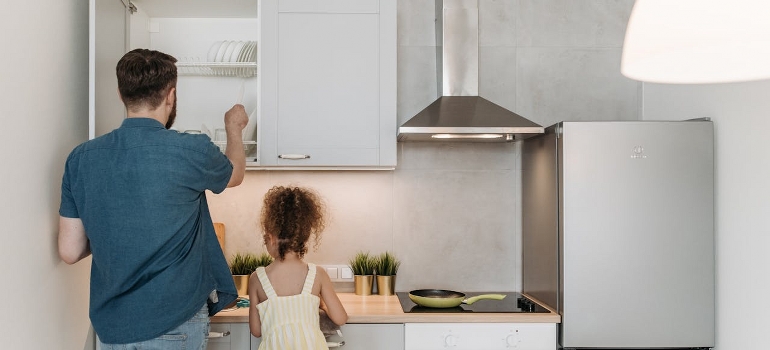 father and daughter packing kitchen